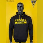 Black hoodie with yellow Alemannia Aachen logo on a bright yellow backdrop, displayed on a mannequin torso.