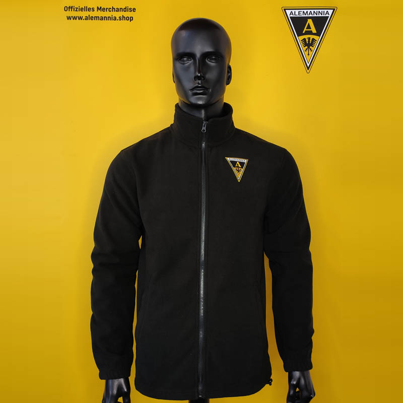 Black zip-front jacket on a mannequin, yellow backdrop, Alemannia crest on the chest.