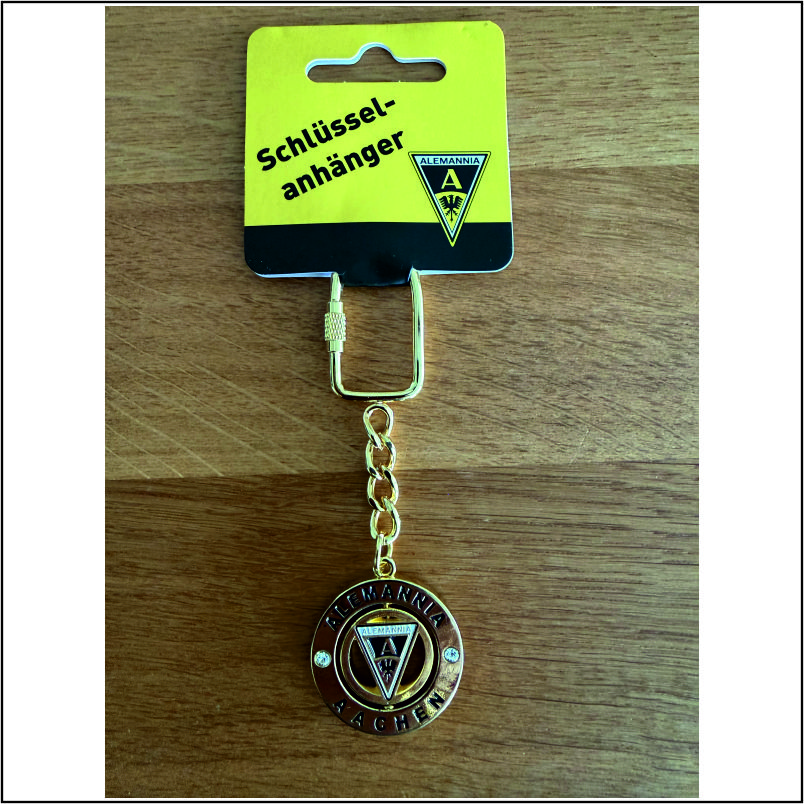 Gold-toned keychain featuring the Alemannia Aachen crest, a circular medallion on a short chain, with yellow packaging reading 'Schlüsselanhänger'