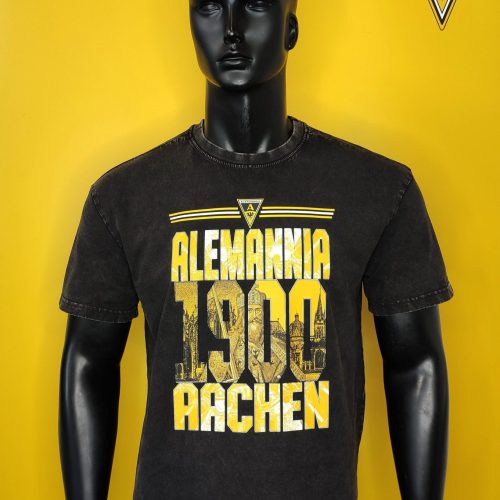 Black mannequin wearing a black T-shirt with yellow Alemannia Aachen graphics on a bright yellow backdrop, with club crest in the corner.