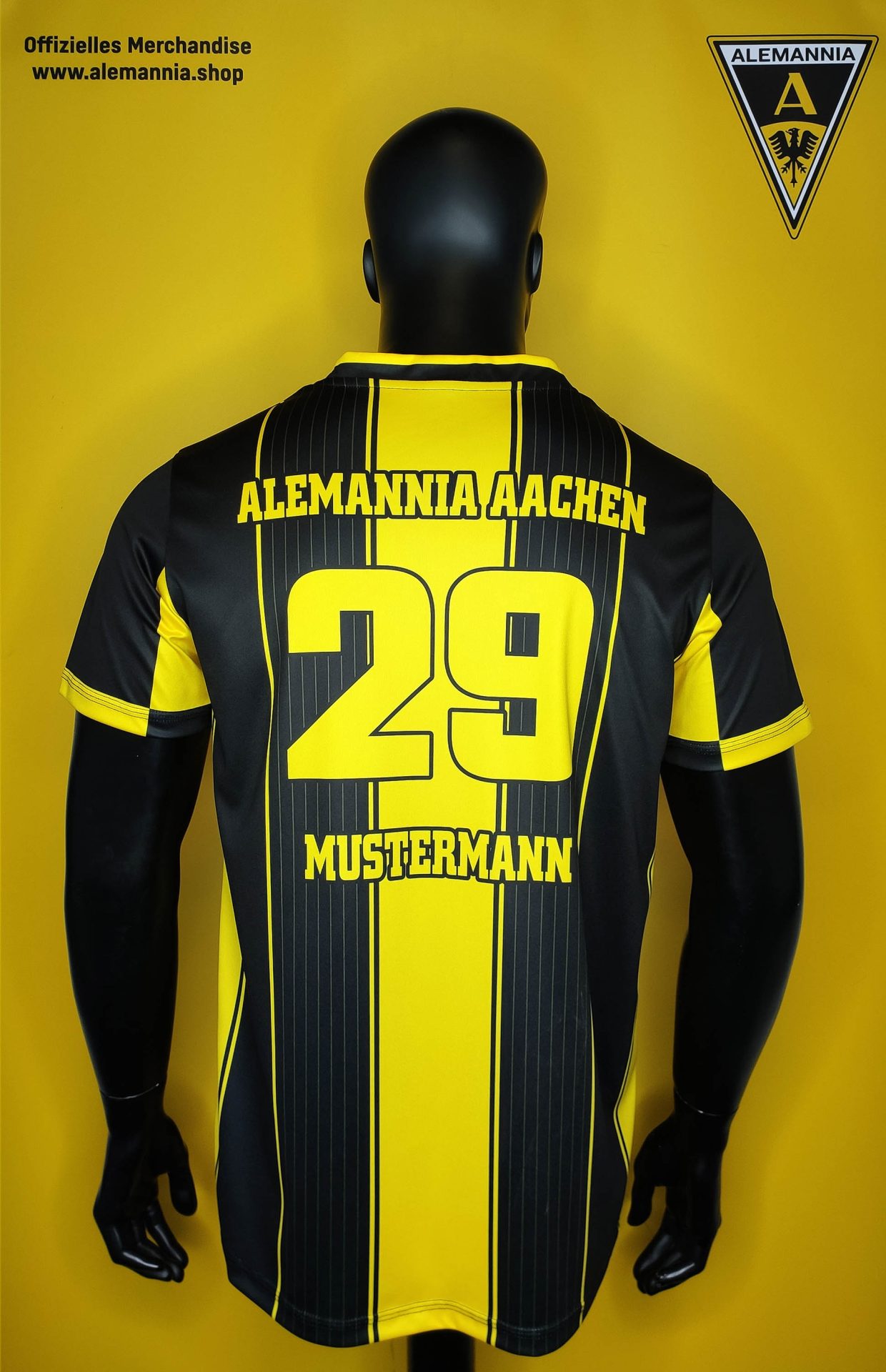 Alemannia Aachen - Stripe design shirt Foto2 - Alemannia Shop Back view of a black-and-yellow Alemannia Aachen jersey on a mannequin, showing the number 29 and the name Mistermann.