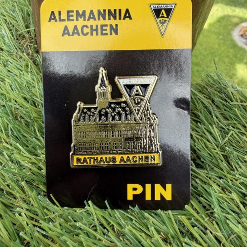 IMG_9296 - Alemannia Shop Gold-colored pin featuring Aachen's town hall illustration and Alemannia Aachen crest, attached to a black and yellow backing plate (RATHAUS AACHEN)