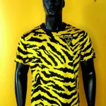 Mannequin wearing a yellow and black tiger-stripe Alemannia football jersey with the club crest on the chest.