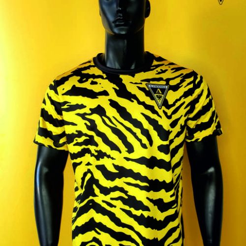 Mannequin wearing a yellow and black tiger-stripe Alemannia football jersey with the club crest on the chest.